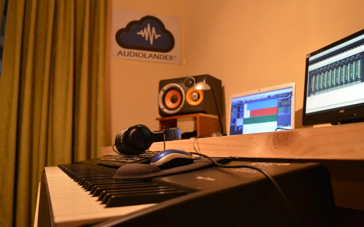 A home-studio desk with a laptop and keyboard