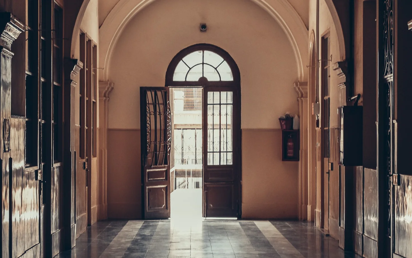 Sunlight falling through an open doorway at the end of a corridor
